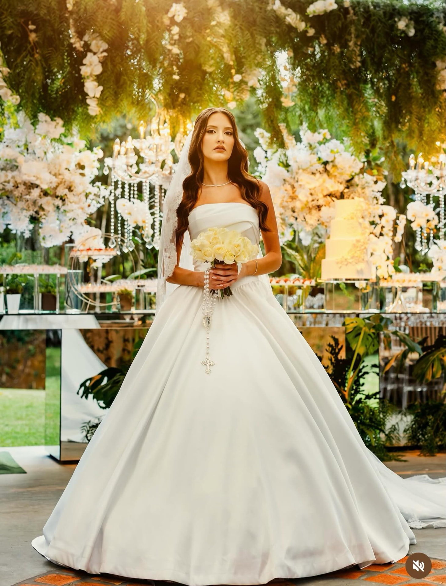 Noiva em jardim decorado com arcos florais e lustres